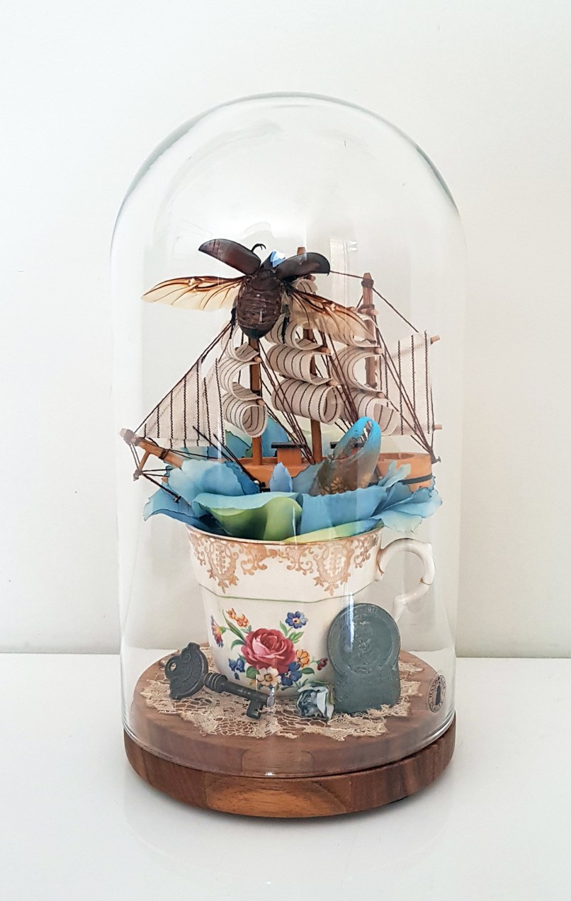 Antique Teacup with 24 carat gold building, antiques, lace, wooden ship, stag beetle, faux flower.